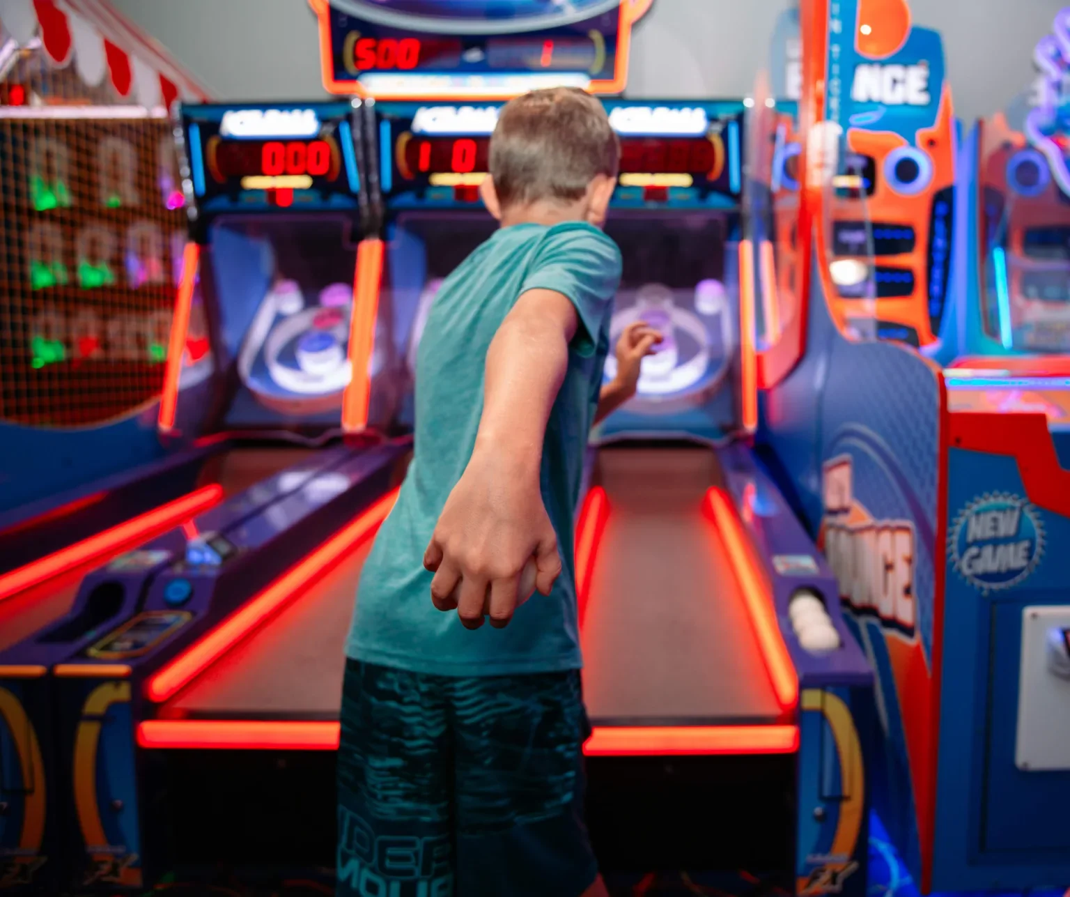 A young guest playing an arcade basketball game